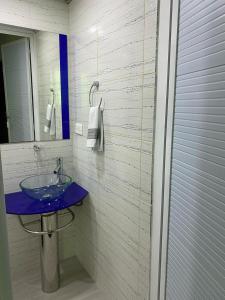 a bathroom with a blue sink and a mirror at HOTEL VILLA DANIELA in Puerto Triunfo