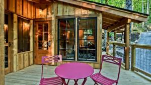a house with a pink table and chairs on a porch at The Poplar in Treehouse Grove at Norton Creek in Gatlinburg
