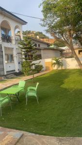 a green table and chairs in the yard of a house at Charming 1-Bed Apartment in Accra in New Weija