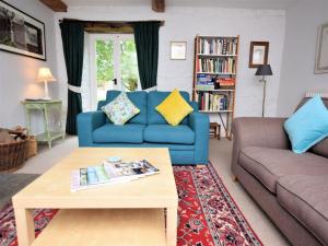 a living room with a blue couch and a coffee table at 3 Bed in Stratford-upon-Avon 54081 in Ettington