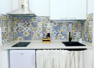 a kitchen with a sink and a tiled wall at Memoir Appartamento Lecce in Lecce