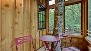 a table and two chairs on the porch of a cabin at The Magnolia in Treehouse Grove at Norton Creek in Gatlinburg