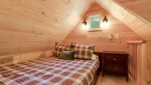 a bedroom with a bed in a log cabin at The Magnolia in Treehouse Grove at Norton Creek in Gatlinburg