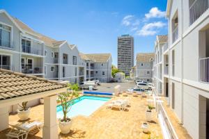 an apartment patio with a swimming pool and buildings at Tranquil Haven with Uninterrupted Power, a Serene Oasis in the Heart of Cape Town in Cape Town