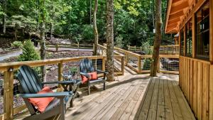 two chairs sitting on a deck next to a house at The Hemlock in Treehouse Grove at Norton Creek in Gatlinburg