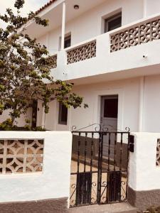 a white building with a gate and a fence at Casa Plaza 1 in Vega de Río de Palmas