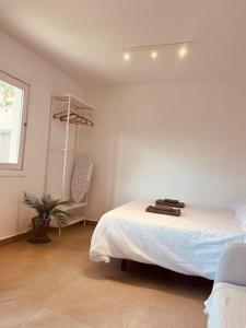 a white bedroom with a bed and a window at Casa Plaza 1 in Vega de Río de Palmas