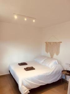 a white bed with two towels on top of it at Casa Plaza 1 in Vega de Río de Palmas