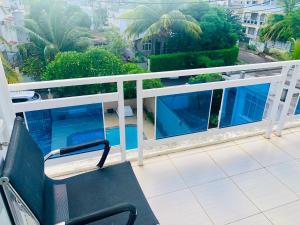 un banc sur un balcon avec vue sur la ville dans l'établissement Villa individuelle avec piscine 5 chambres, à Flic-en-Flac
