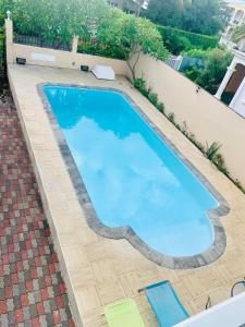 une image d'une piscine d'eau bleue dans l'établissement Villa individuelle avec piscine 5 chambres, à Flic-en-Flac