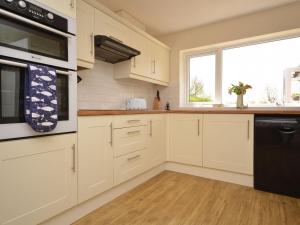 uma cozinha com armários brancos e uma janela em 2 Bed in Sutton On Sea 42804 em Anderby