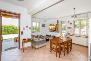 een keuken en een woonkamer met een tafel en stoelen bij Delightful 4 Bed Villa with Heated pool & Jacuzzi Overlooking Aeolian Islands in Castroreale