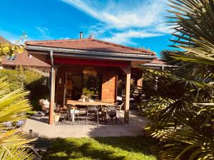 a house with a patio with a table and chairs at Villa Marie in Sévrier