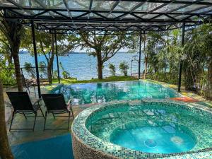 a swimming pool with chairs and a view of the water at Las Luciernagas Hotel Boutique in Flores