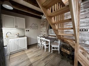 a kitchen and dining room with a table and chairs at oBłędne Chaty in Radków