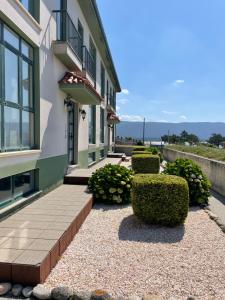 a building with bushes and a walkway next to a building at APARTAMENTO CON EXCELENTES VISTAS AL MAR EN LA PLAYA DE CARNOTA in Caldebarcos