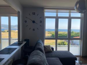a living room with a clock on the wall at APARTAMENTO CON EXCELENTES VISTAS AL MAR EN LA PLAYA DE CARNOTA in Caldebarcos