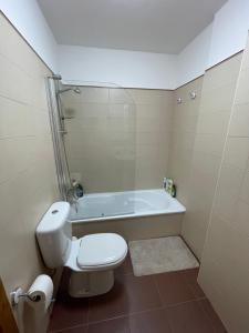 a bathroom with a toilet and a bath tub at APARTAMENTO CON EXCELENTES VISTAS AL MAR EN LA PLAYA DE CARNOTA in Caldebarcos