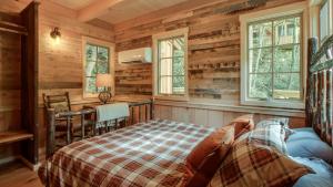 a log cabin bedroom with a bed and a desk at The Cedar in Treehouse Grove at Norton Creek in Gatlinburg