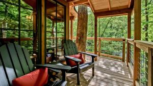 two chairs on the porch of a tree house at The Cedar in Treehouse Grove at Norton Creek in Gatlinburg