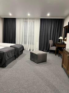 ドゥブノにあるХмелярのベッドとデスクが備わるホテルルームです。
