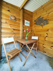 a wooden cabin with a table and two chairs at Ti Grounouy in Le Diamant