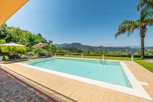 een zwembad in een resort met palmbomen bij Delightful 4 Bed Villa with Heated pool & Jacuzzi Overlooking Aeolian Islands in Castroreale