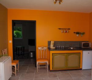 LE GOÛT DES CHOSES في Chevagnes: مطبخ برتقالي مع حوض ومكتب