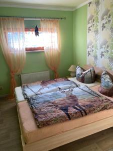 1 dormitorio con 1 cama con una pintura en la pared en Natur pur mit Fernblick für Wanderfreunde en Bad Sachsa