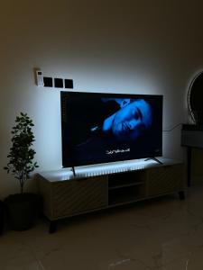 einen Flachbild-TV auf einem Stand in einem Wohnzimmer in der Unterkunft استديو مميز بدخول ذاتي in Riad