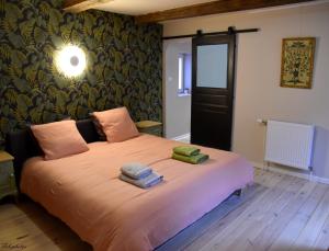 - une chambre avec un grand lit et des serviettes dans l'établissement Belgica-Melay 52400, à Melay