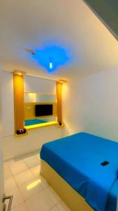 a bedroom with a blue bed in a room at DND Room Aero in Teko
