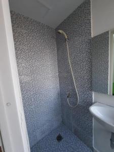 La salle de bains est pourvue d'une douche et d'un lavabo. dans l'établissement DND Room Aero, à Teko