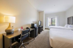a hotel room with a bed and a desk with a computer at Comfort Suites Lawton Near Fort Sill in Lawton +5 photos