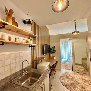 een keuken met een wastafel en een woonkamer bij New Cozy Staycation in Tagaytay in Tagaytay