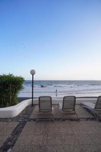 two chairs and a lamp next to the beach at Playa Chica Beachfront Apartment in Santa Cruz de Tenerife