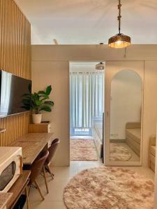 een woonkamer met een tafel en stoelen en een spiegel bij New Cozy Staycation in Tagaytay in Tagaytay