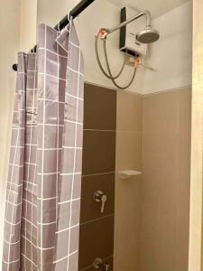 een douche met een douchegordijn in de badkamer bij New Cozy Staycation in Tagaytay in Tagaytay