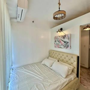 een bed in een kamer met een witte muur bij New Cozy Staycation in Tagaytay in Tagaytay