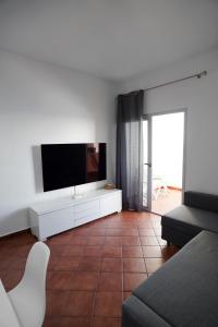 a living room with a flat screen tv and a couch at Playa Chica Beachfront Apartment in Santa Cruz de Tenerife