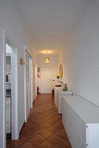 a hallway with a white room with a white table at Playa Chica Beachfront Apartment in Santa Cruz de Tenerife