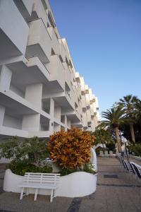 a building with a white bench in front of it at Playa Chica Beachfront Apartment in Santa Cruz de Tenerife