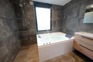 Recreatiepark de Koornmolen في Zevenhuizen: حمام مع حوض استحمام ونافذة
