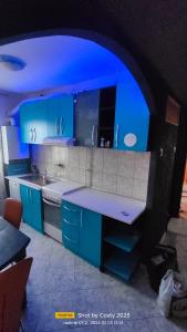 a kitchen with blue cabinets and a counter top at Central City Park in Bacău