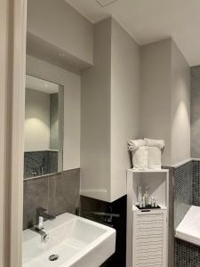 a white bathroom with a sink and a mirror at PRIMA FILA in Sanremo