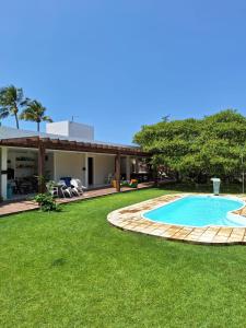 een achtertuin met een zwembad en een huis bij Vila Gameleira Garça in Maceió