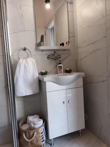 W łazience znajduje się umywalka i lustro. w obiekcie Στούντιο Διπλα στην Ακρόπολη w Atenach