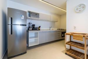 einen Kühlschrank aus Edelstahl in einer Küche mit weißen Schränken in der Unterkunft Elegância Tropical San Martin - Destino BSM 303 C in Barra de São Miguel