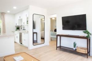 a living room with a tv and a mirror at Live the Beach Life in a Quaint Shell Cottage in Del Mar