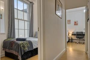 a bedroom with a bed and a large window at Cosy 2BR Retreat near Paddington Station in London